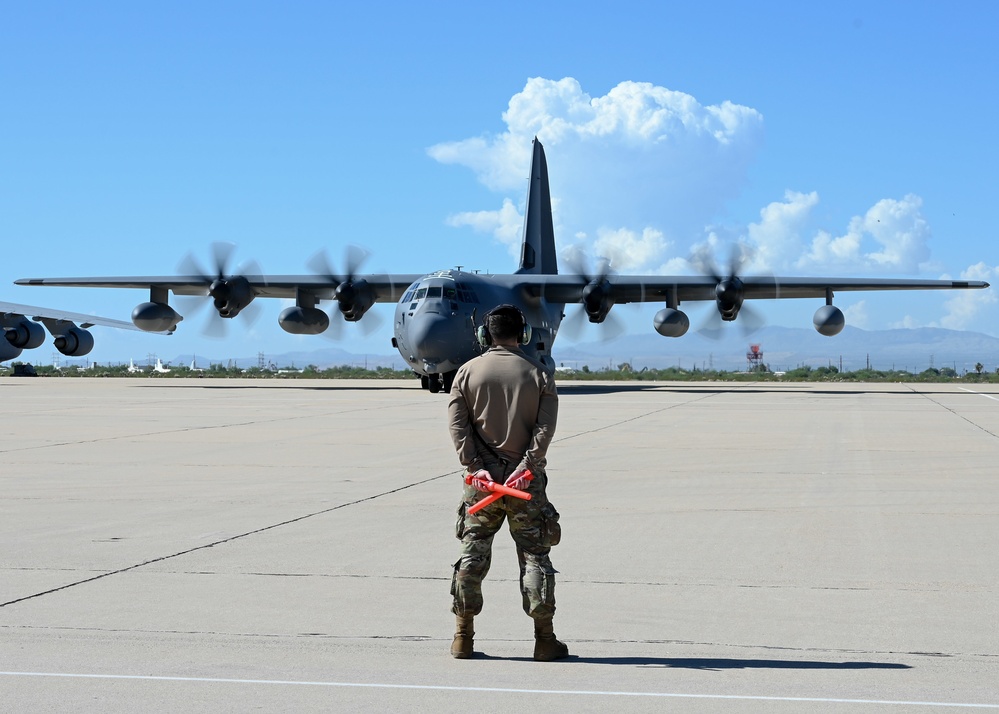 U.S. Air Force ground crew member marshalling an aircraft on a flightline